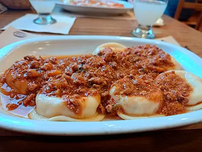 Plato de sorrentinos con salsa bolognesa