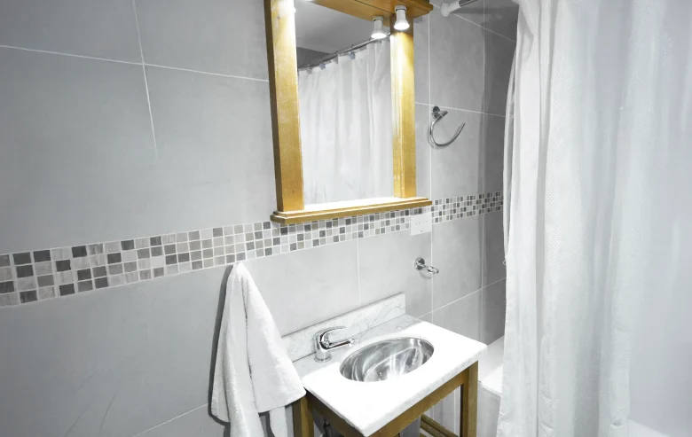 Baño con bacha integrada, espejo con marco de madera y bañera, correspondiente a la Casa 1