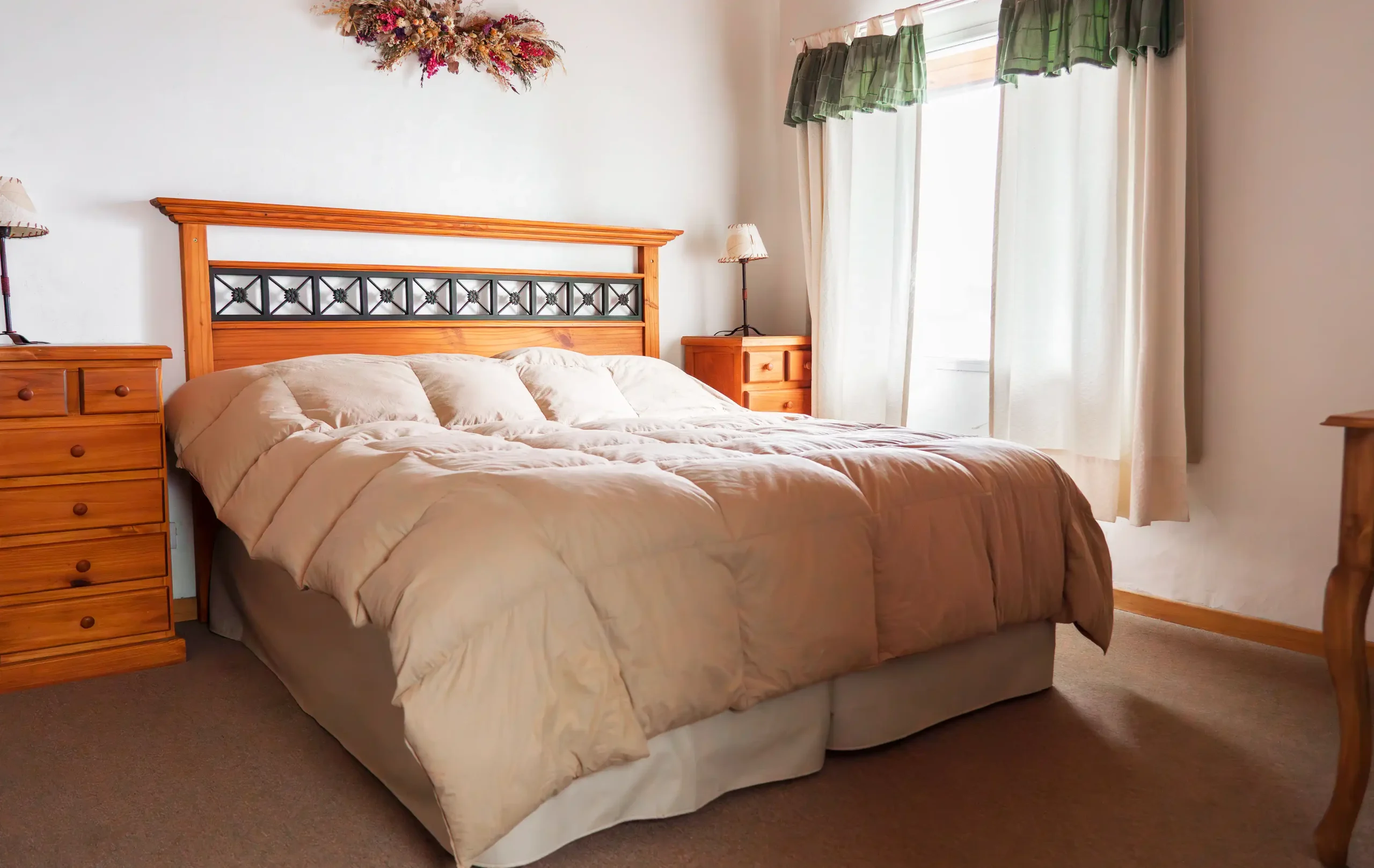 Dormitorio principal con cama matrimonial, mesitas de luz y veladores, con ventana y cortinas, correspondiente a la Casa 3