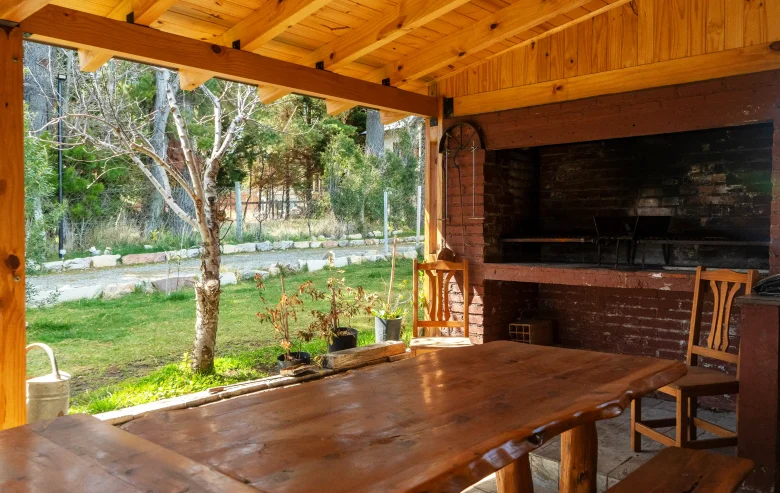 Sector parrilla de madera con mesa grande en madera y patio
