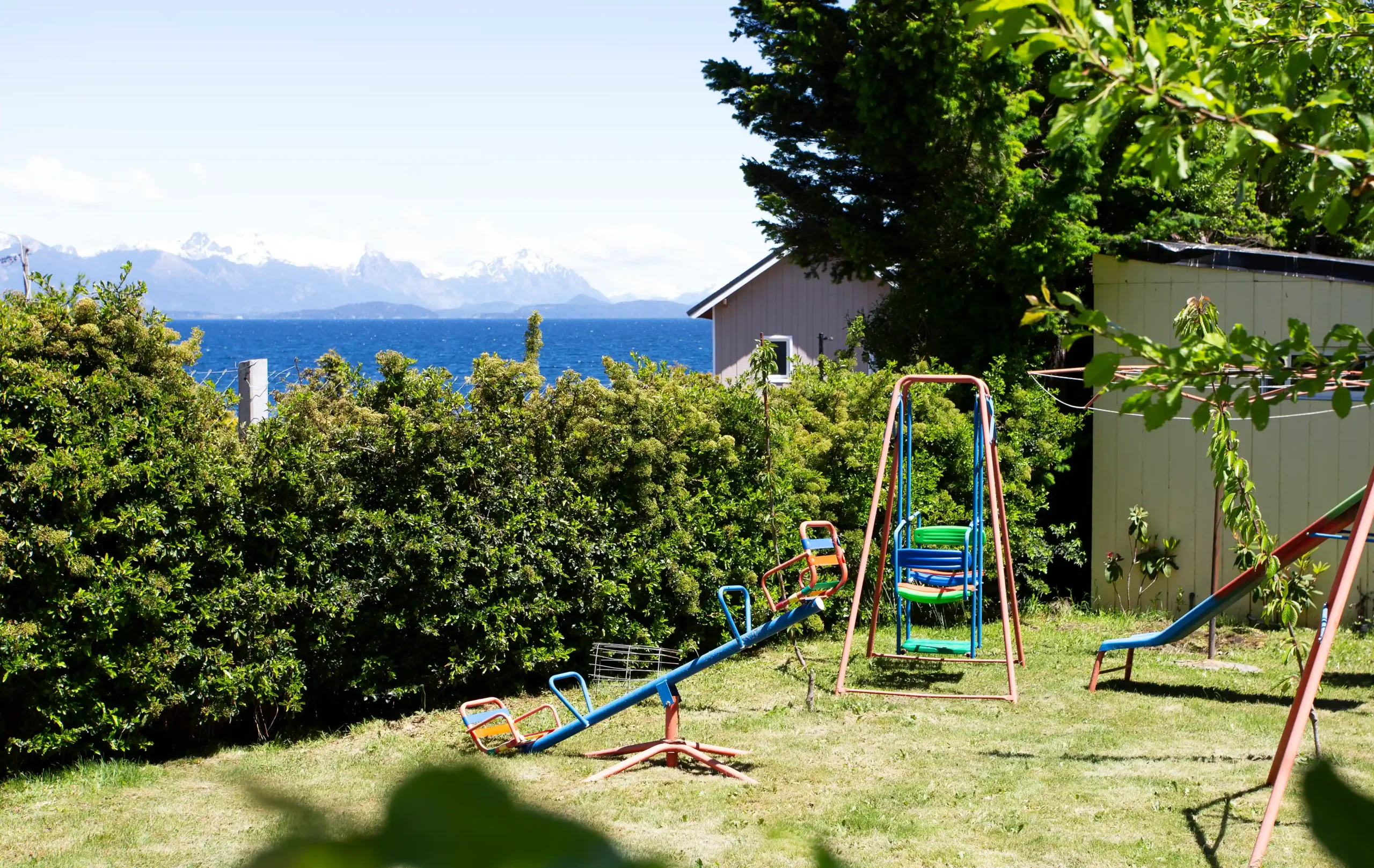 Casa con patio amplio con juegos para niños y vista al lago y montañas