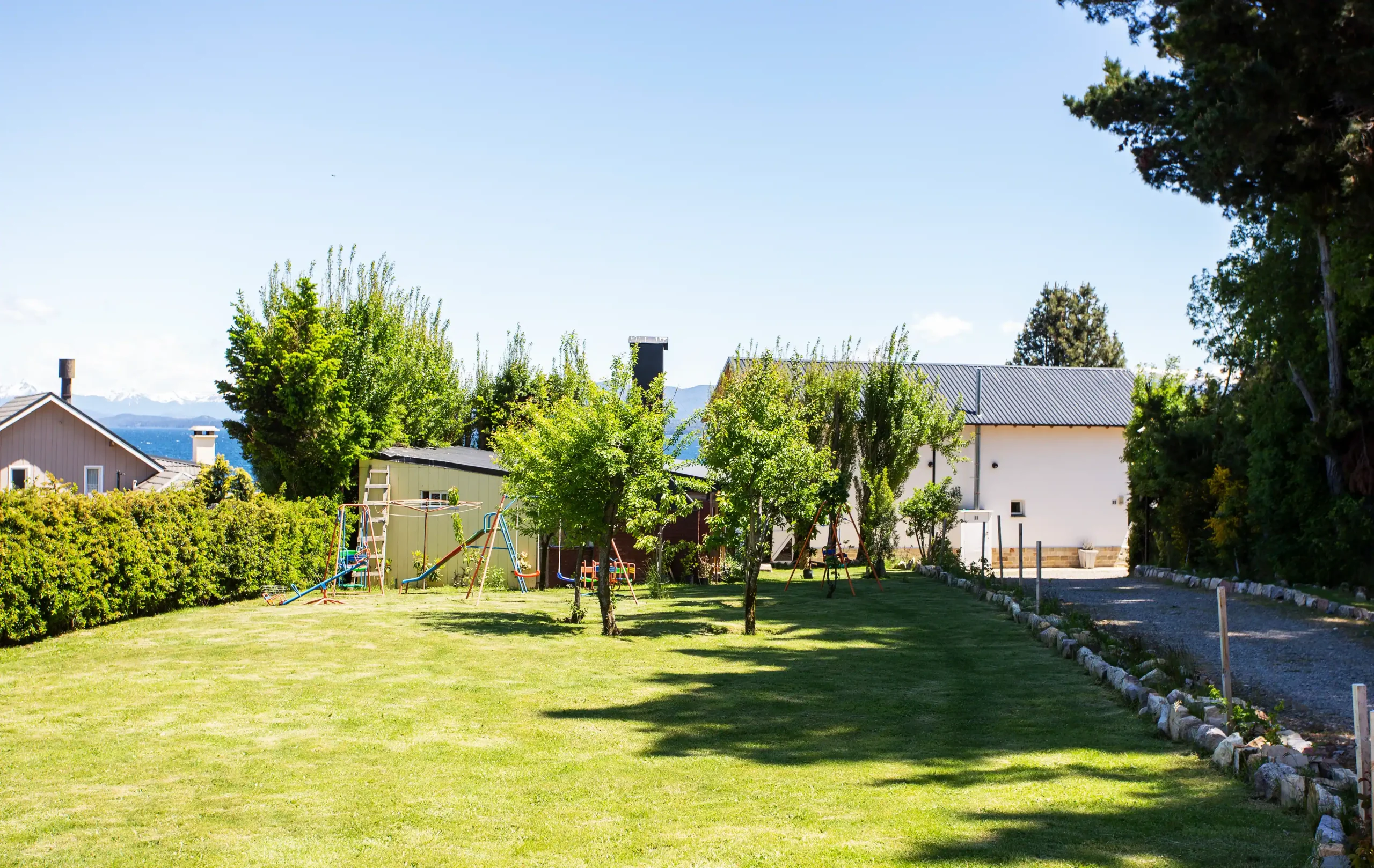 Casa con patio amplio con juegos para niños y vista al lago y montañas