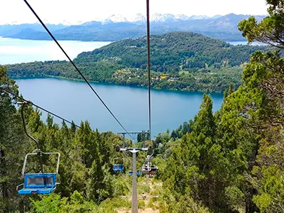 Vista desde las aerosillas del cerro campanario. Se visualiza el lago, bosque y montañas de fondo.